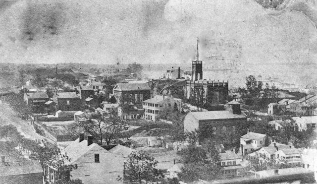 View of Vicksburg taken from the top of the courthouse looking to the southwest. In the distance is the spire of St. Paul's Catholic Church.